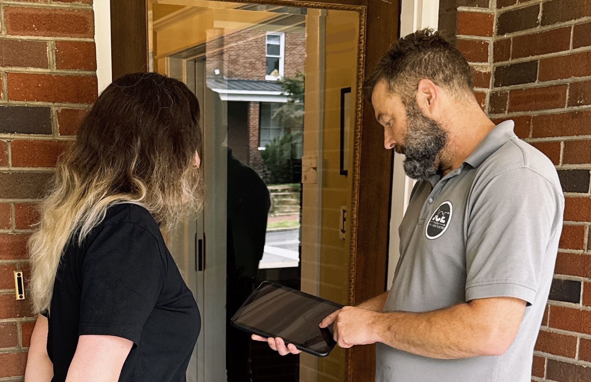 John Calhoun Electric and HVAC service professional assisting a customer at her home
